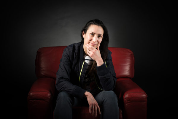 photo d'Alpheratz, en position assise sur un canapé rouge.'